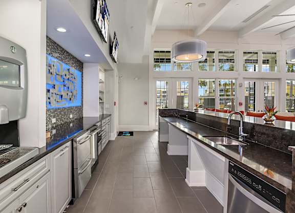 A modern kitchen with a long counter and a dishwasher.