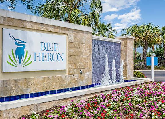 A sign for Blue Heron with a logo of a blue heron and a waterfall.