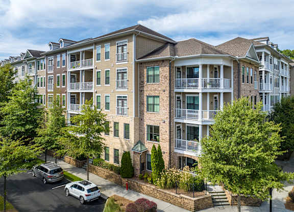 A large apartment complex with a parking lot in front.