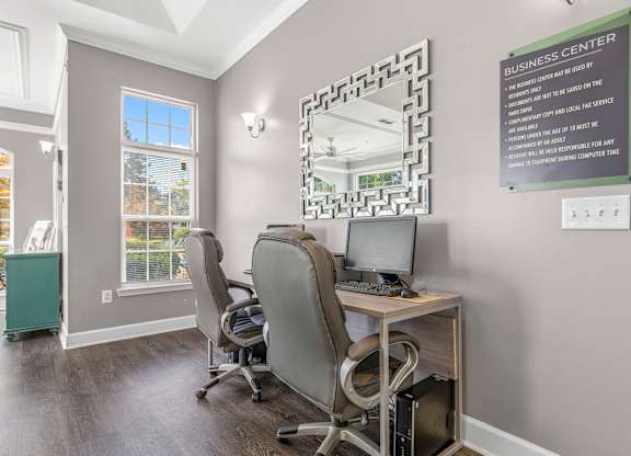 A business center with a sign on the wall and a mirror on the desk.