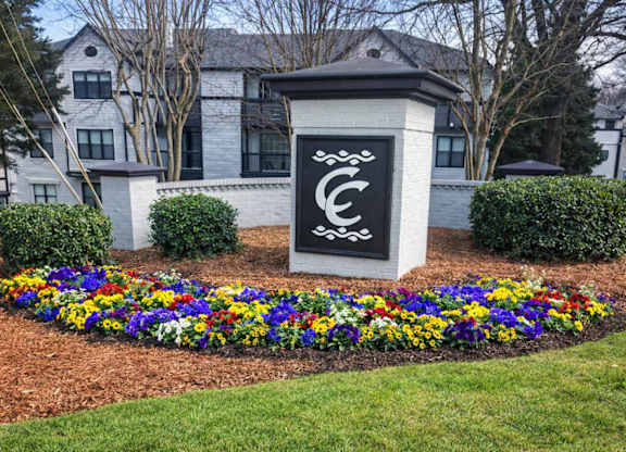 A sign with a C on it is in front of a building.