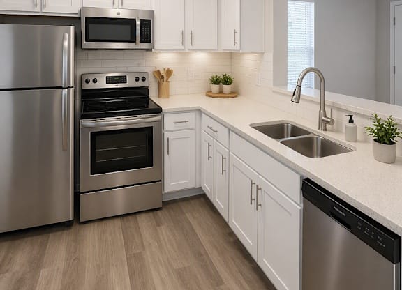 A modern kitchen with stainless steel appliances and wooden flooring.