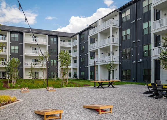 a courtyard between two apartment buildings with benches and grass