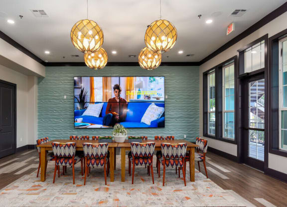 a dining room with a table and chairs and a tv on the wall
