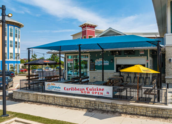 the outside of a restaurant with tables and umbrellas