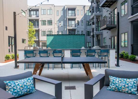 A patio with a table and chairs with a blue cushion.