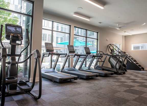 A gym with treadmills, elliptical machines, and a stair climber.
