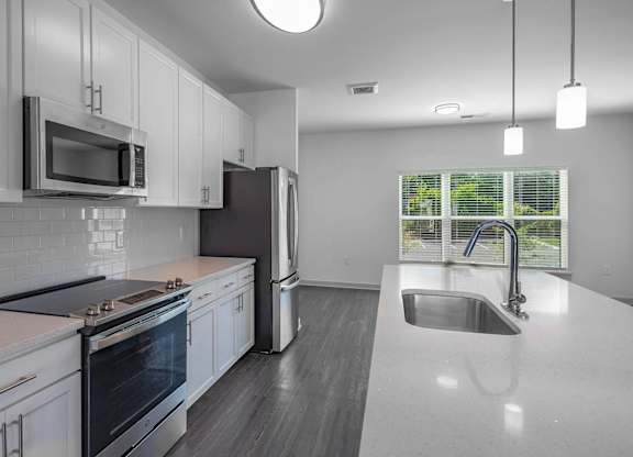 a kitchen with white cabinets and a sink
