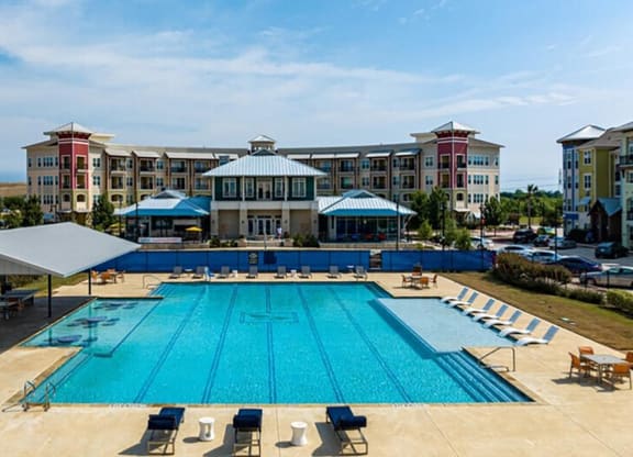 an aerial view of a swimming pool with apartments in the background