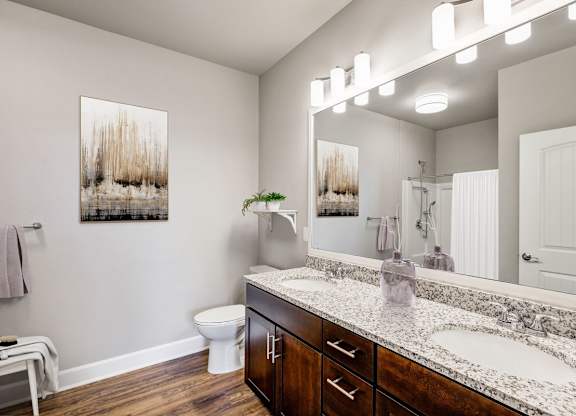 A bathroom with a toilet, sink, and a mirror.