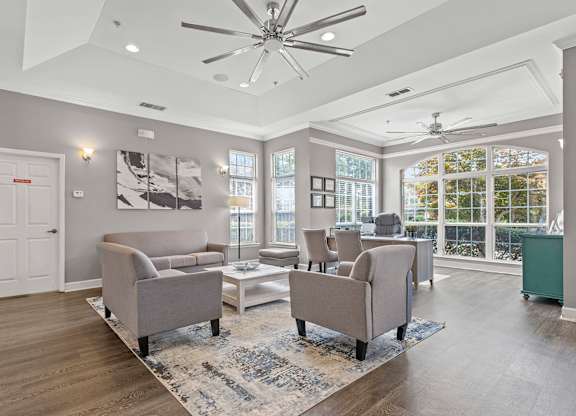 A spacious living room with a grey sofa set and a white coffee table.