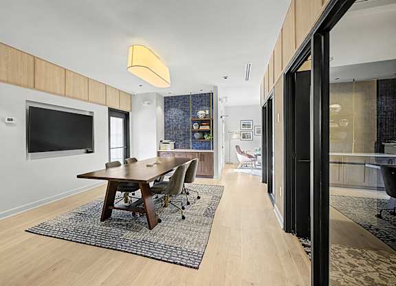 A modern dining room with a wooden table and chairs.