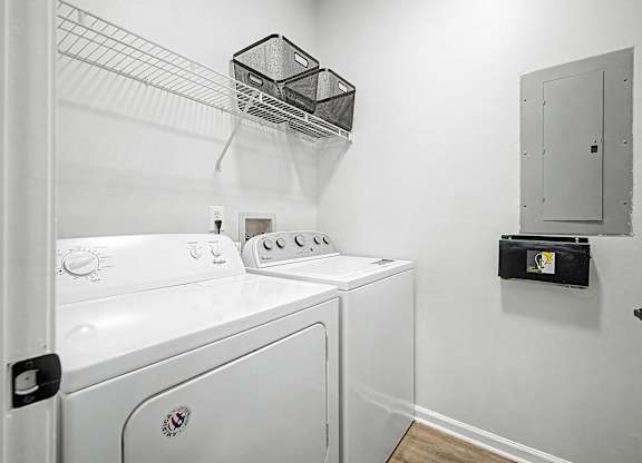 A white dryer and washer in a small laundry room.