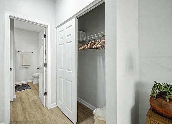 A white bathroom with a toilet, a sink, and a towel rack.