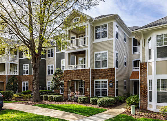 Apartment building with a tree in front of it.