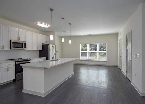 an empty kitchen with white cabinets and a white counter top