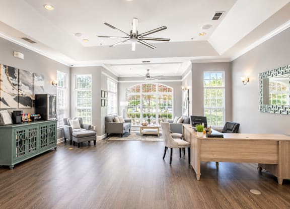 A spacious room with a ceiling fan, a desk, and a couch.