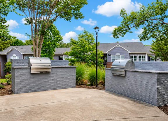 A house with a driveway and a tree in front of it.