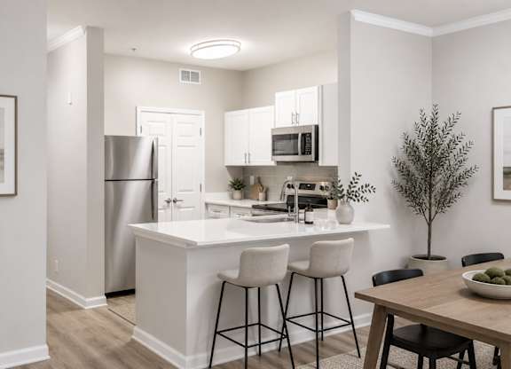 A modern kitchen with white cabinets and a wooden table.