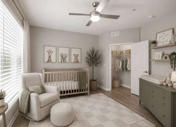 A baby nursery with a white crib, a white chair, and a white ottoman.