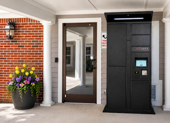 A black vending machine is on the porch of a house.