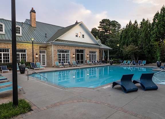 Three-Bedroom Luxury Apartments in Atlanta, GA - The Eliza on Collier - Swimming Pool with In-Water Loungers, Sun Loungers, Pergola, and View of the Clubhouse.