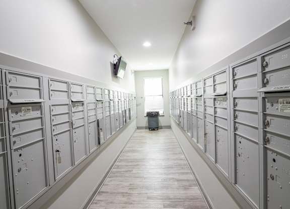 A long hallway with a series of lockers on the wall.