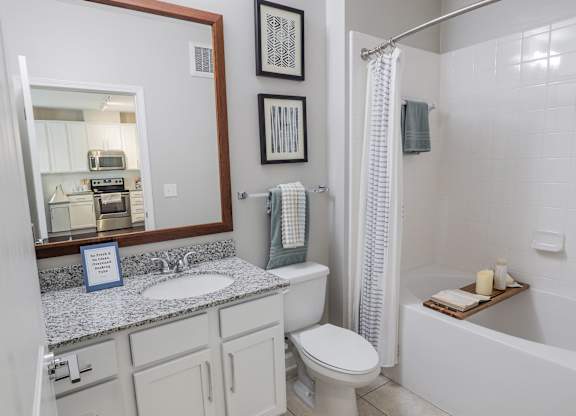 A bathroom with a toilet, sink, and bathtub.