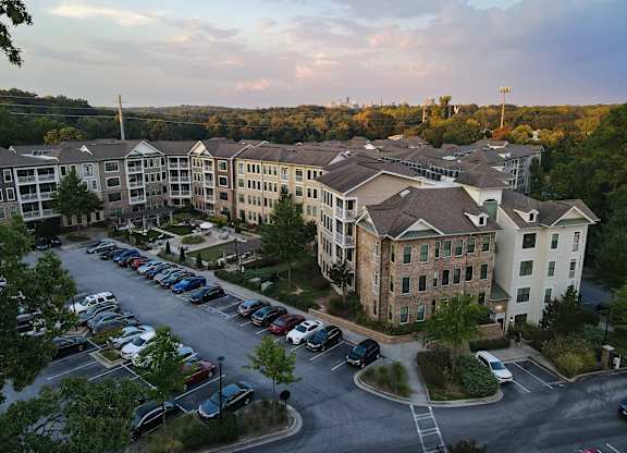 A parking lot is in front of apartment buildings.