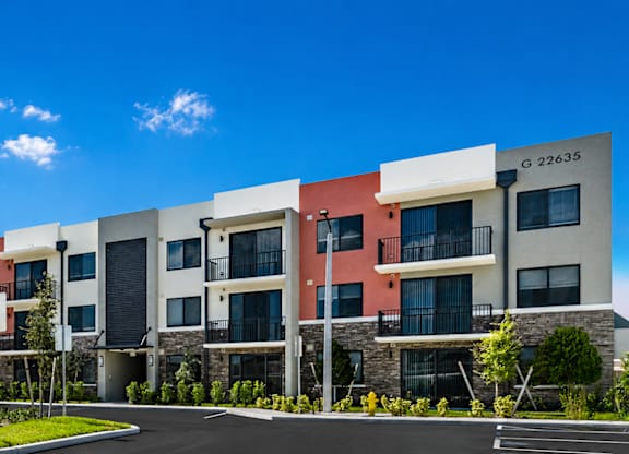 Apartment building with a mix of red, beige, and white exterior colors.