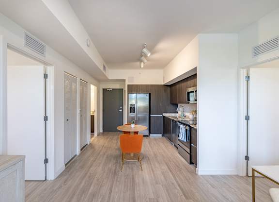 A modern kitchen with a dining table and chairs.