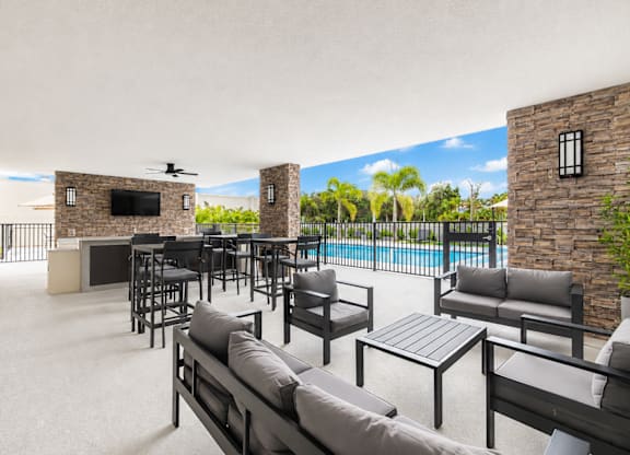 A patio with a pool and furniture.