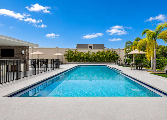 A large outdoor swimming pool surrounded by a black fence.