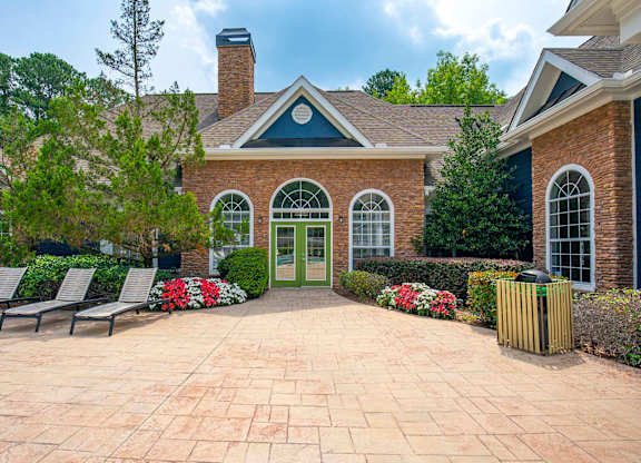 A brick house with a green door and a brick patio.