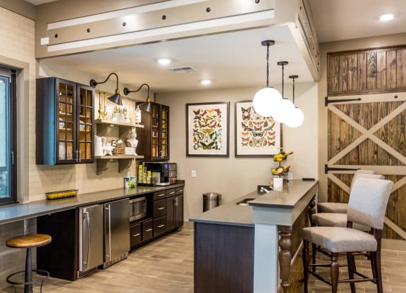 a large kitchen with a counter and a bar with chairs