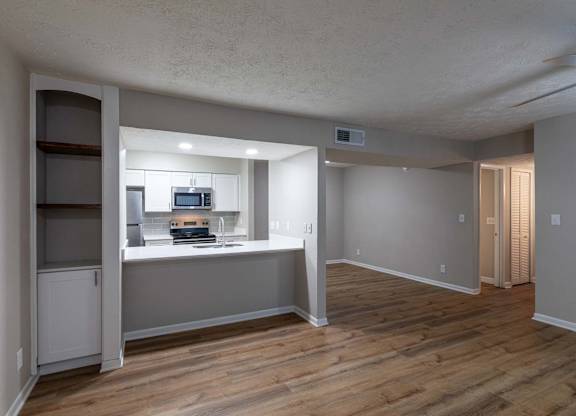 A kitchen with a microwave, oven, and refrigerator.
