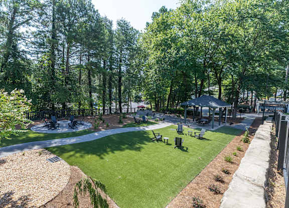 A park with a grassy area, trees, and a bench.