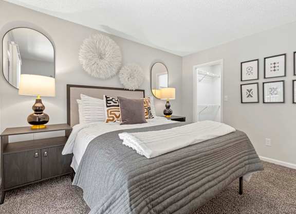 A bedroom with a large bed and two lamps.