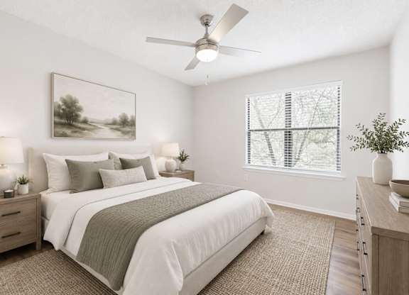 A bedroom with a large bed, a ceiling fan, and a painting on the wall.