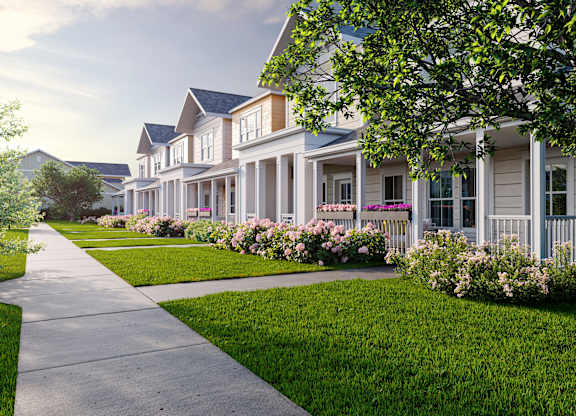 a row of houses with flowers in front of them on a sidewalk