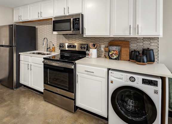 a kitchen with white cabinets and stainless steel appliances at Tower on Tenth Apartments, Birmingham, AL