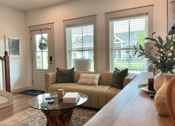 A living room with a couch, coffee table, and a plant at Allier Foley, Foley