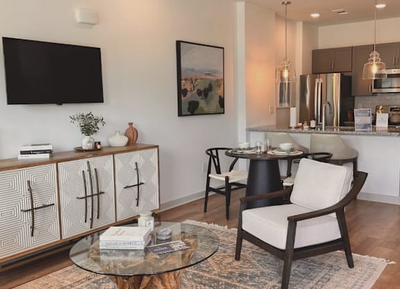 A modern living room with a glass coffee table and a TV mounted on the wall at Allier Foley, Foley, Alabama