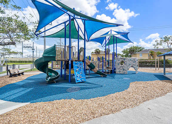 A playground with a blue slide and a green slide.