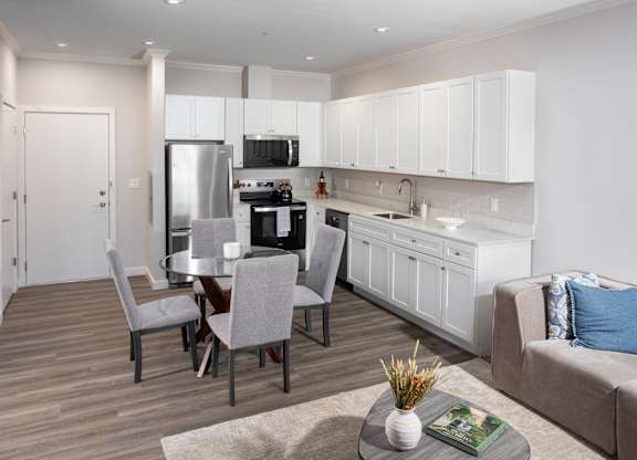 A modern kitchen with a dining table set for four.