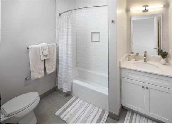 A white bathroom with a toilet, sink, and shower.