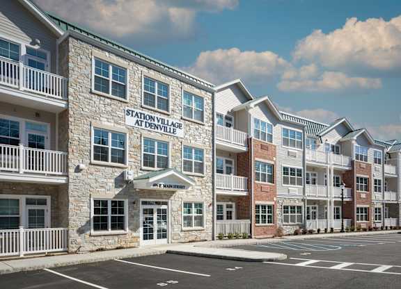 A building with a sign that says Station Village at Denville.