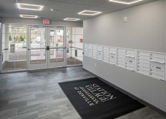 A hallway with a black mat that says "Silhouette Denville".