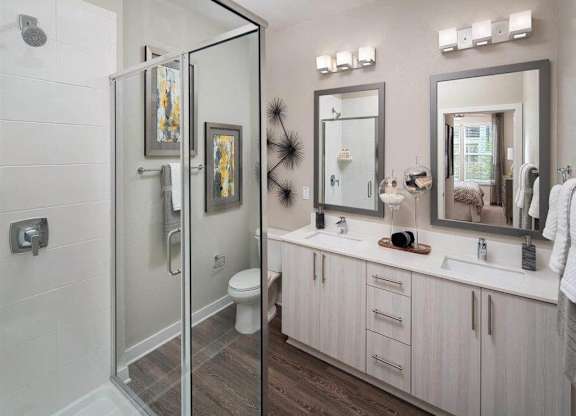Glass enclosed shower and double vanity sinks
