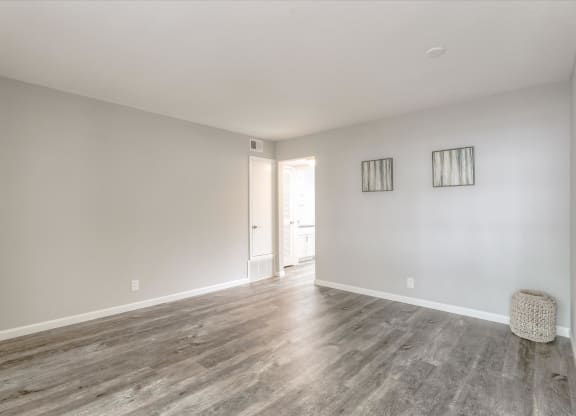 a living room with white walls and wood floors